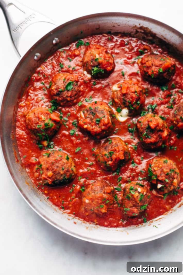 Cheesy Stuffed Meatballs in Homemade Tomato Sauce - The perfect meal for spaghetti and meatball night! Or serve them as party appetizers for New Years, Christmas, and Super Bowl parties! #stuffedmeatballs #cheesestuffedmeatballs #homemadetomatosauce | Littlespicejar.com