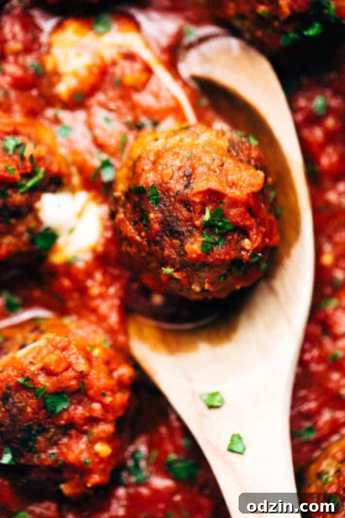 Cheesy Stuffed Meatballs in Homemade Tomato Sauce - The perfect meal for spaghetti and meatball night! Or serve them as party appetizers for New Years, Christmas, and Super Bowl parties! #stuffedmeatballs #cheesestuffedmeatballs #homemadetomatosauce | Littlespicejar.com