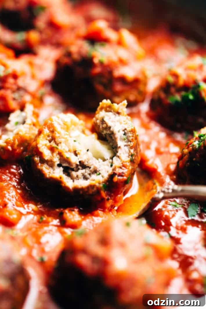 Cheesy Stuffed Meatballs in Homemade Tomato Sauce - The perfect meal for spaghetti and meatball night! Or serve them as party appetizers for New Years, Christmas, and Super Bowl parties! #stuffedmeatballs #cheesestuffedmeatballs #homemadetomatosauce | Littlespicejar.com