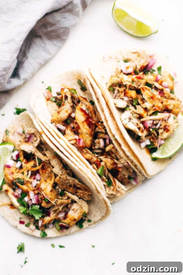 Pressure Cooker Crispy Chicken Carnitas - The easiest way to make carnitas! This instant pot recipe makes the most delicious carnitas! Top with lots of cilantro, onions, sautéed cabbage, and homemade chipotle sauce! #instantpot #carnitas #chickencarnitas #pressurecooker | Littlespicejar.com chicken tacos on white marble board