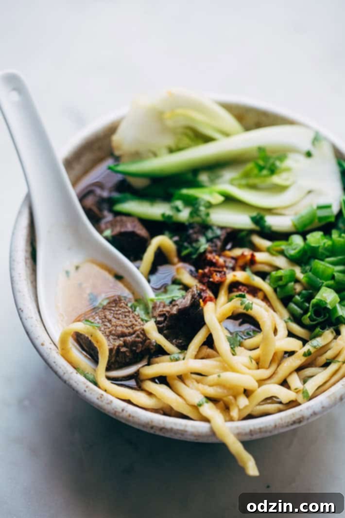 Comfy Cozy Taiwanese Beef Noodle Soup - thick and chewy noodles in a homemade. slow simmered broth with tons of tender beef and fresh greens! #beefnoodlesoup #beefsoup #taiwanesebeefnoodlesoup #asiannoodlesoup | Littlespicejar.com