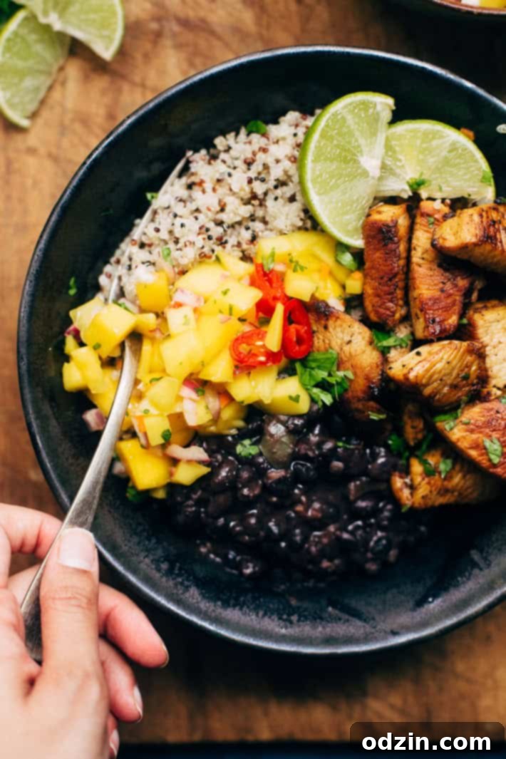 Tropical Mojo Chicken Quinoa Bowls with Mango Salsa and Black Beans 4 Delicious Cuban Mojo Chicken Quinoa Bowl served with lime wedges