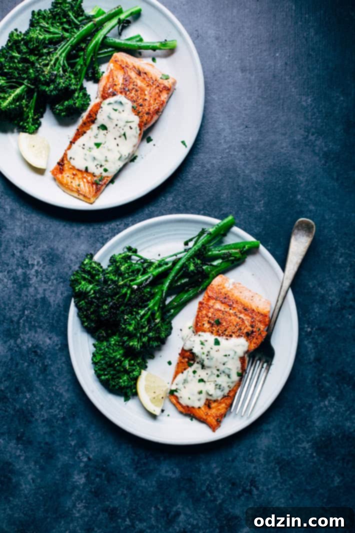 A fork taking a bite of tender pan-seared salmon, showcasing its moist texture.
