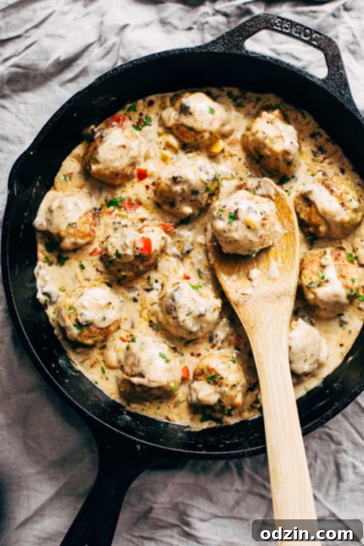 Cajun Chicken Meatballs in Tasty Cream Sauce, garnished with fresh basil.