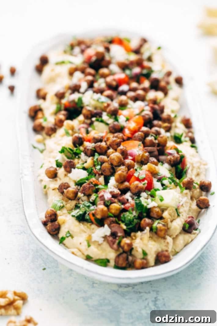 Seven Layer Chickpea Shawarma Dip - Smooth hummus topped with a parsley salad, salty feta, crunchy roasted chickpeas, and so much more! #7layerdip #sevenlayerdip #shawarma #shawarmadip #roastedchickpeas #sponsored by @californiawalnuts | Litttlespicejar.com