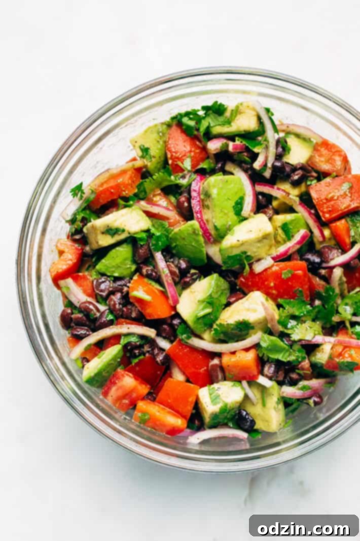 Close-up of a vibrant Black Bean Tomato Avocado Salad, showcasing ripe avocado, juicy tomatoes, and hearty black beans. A simple, flavor-packed meal that echoes the taste of fresh guacamole. #avocado #avocadosalad #tomatoavocadosalad #blackbeansalad