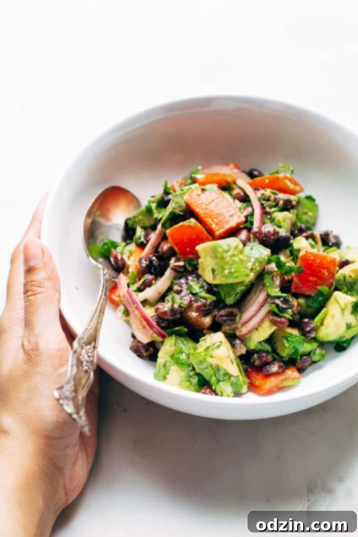 A serving of Black Bean Tomato Avocado Salad with a hint of smoky chili powder, showcasing its appetizing appeal. This simple and healthy salad is a fantastic alternative to traditional guacamole. #avocado #avocadosalad #tomatoavocadosalad #blackbeansalad