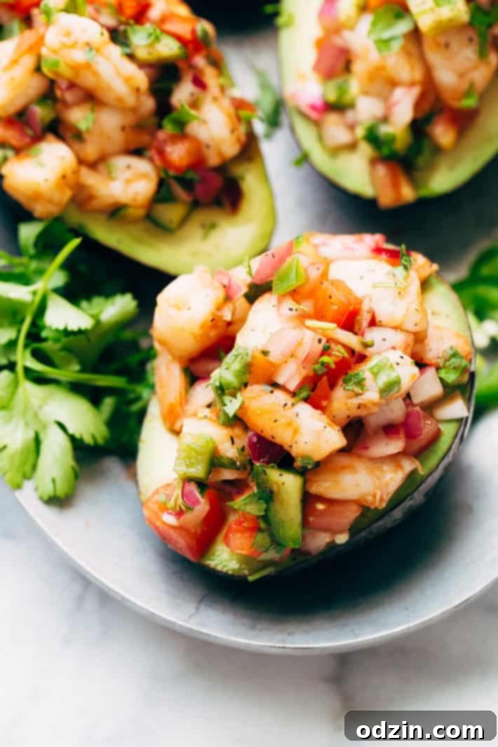 Avocado halves generously topped with colorful Mexican shrimp cocktail, ready to be served.