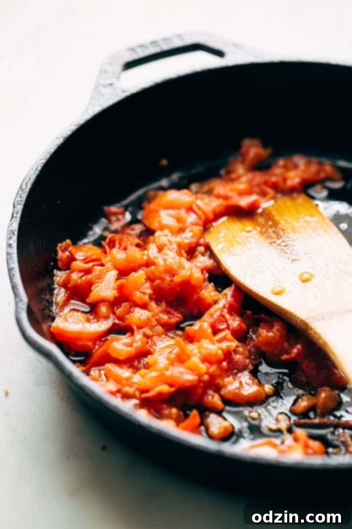 Tomato Masala Base for Shrimp Cooking the base masala: Diced tomatoes simmering in oil, forming a rich paste with ginger, garlic, and jalapenos for the spicy shrimp masala.