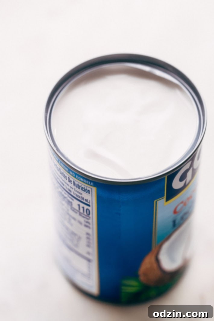 Overhead shot of a bowl of creamy chicken coconut noodle soup with lime and cilantro garnish