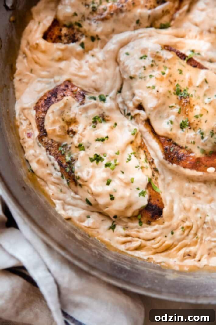 chicken covered in balsamic onion cream sauce in skillet