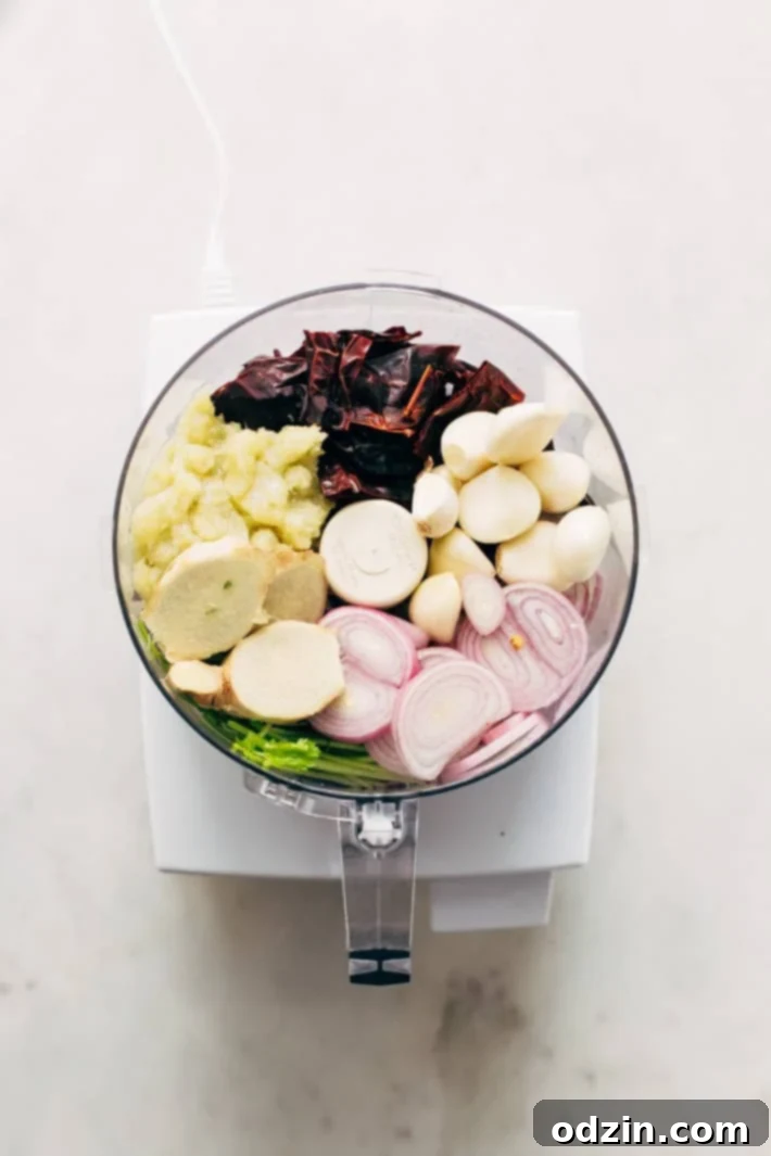 Homemade Thai Massaman Curry Paste - A quick 15 minute paste that's perfect to use in all kinds of curries! This can also be made vegan/vegetarian friendly. #massamancurry #homemadecurrypaste #thaicurry #massamancurrypaste | Littlespicejar.com A close-up of a mortar and pestle with toasted whole spices, highlighting the traditional method of preparing curry paste.