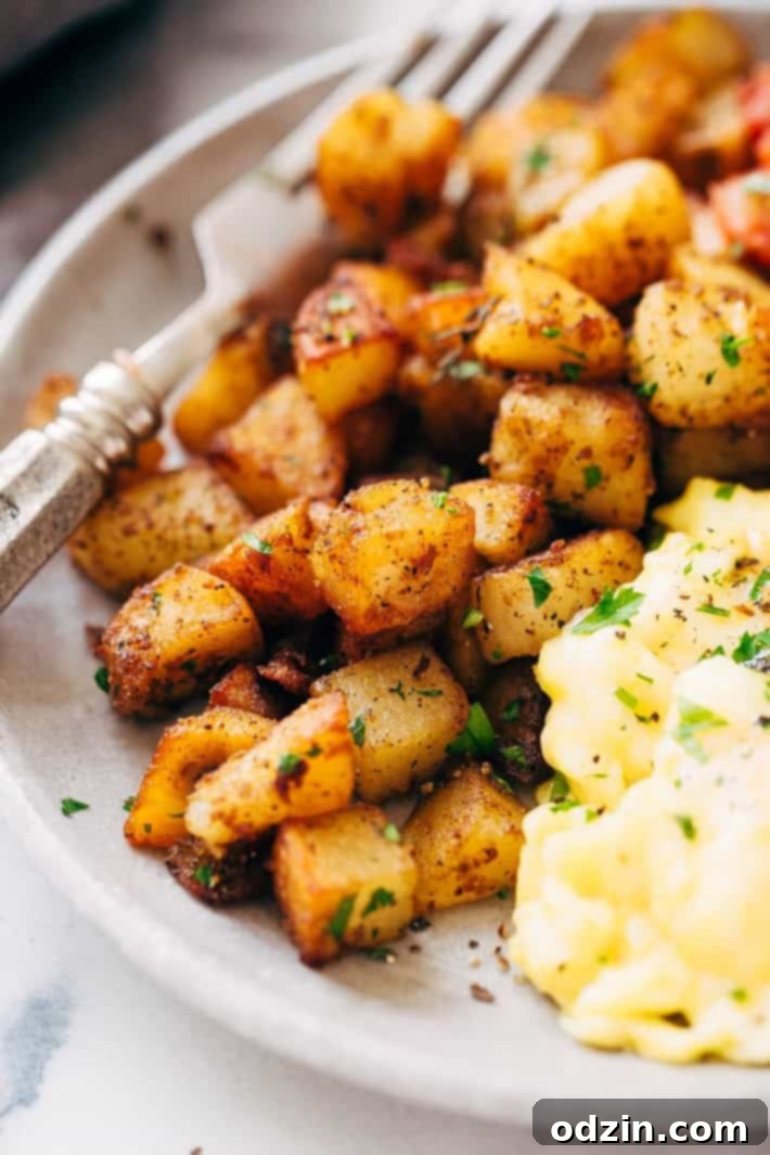 Close up of the perfectly crisp, golden brown texture of skillet breakfast potatoes on a grey plate, showcasing the delicious crust