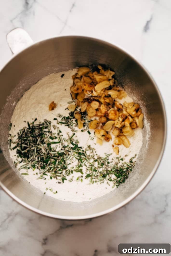stand mixer bowl holding dry ingredents for focaccia bread with roasted garlic and rosemary