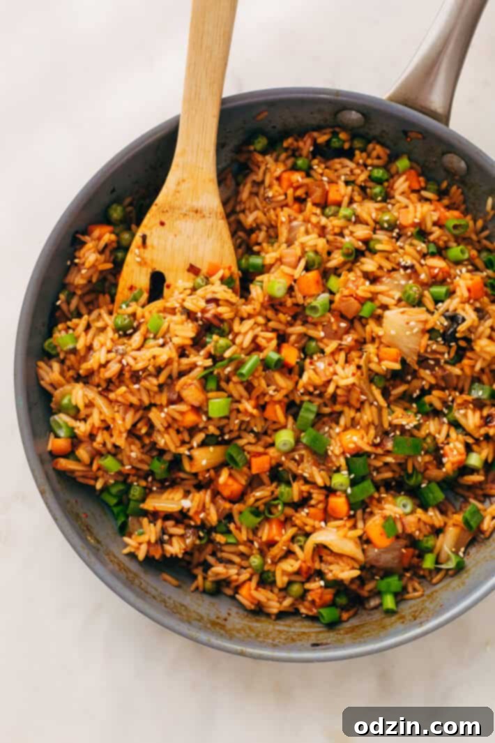 Kimchi Fried Rice with Fried Egg - A quick and easy meal A serving of kimchi fried rice with a perfectly fried egg on top, garnished with fresh green onions.