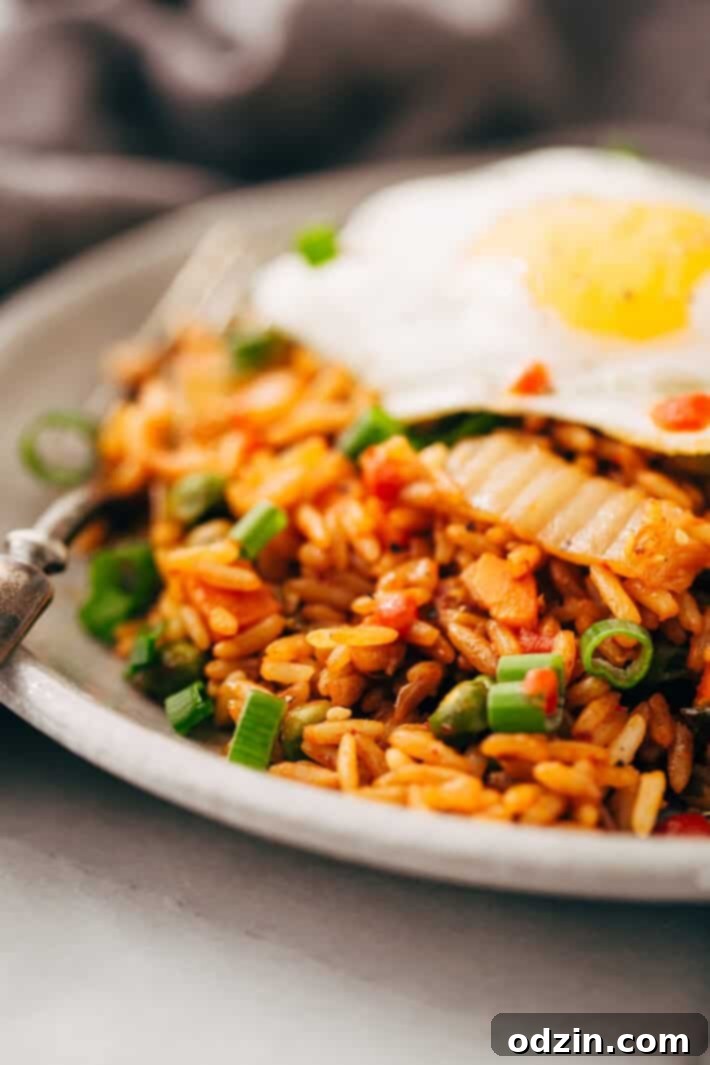 Final stage of cooking Kimchi Fried Rice in a skillet Cooked kimchi fried rice in a large skillet, with all ingredients mixed, ready to be served.