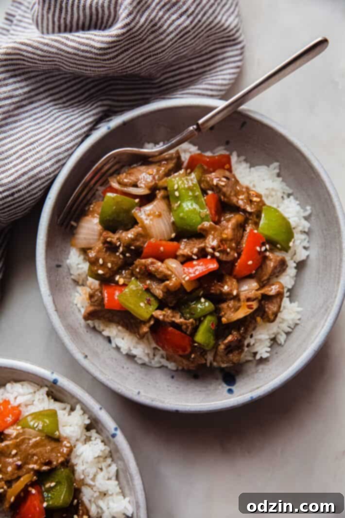 bowl of rice topped with pepper steak stir fry