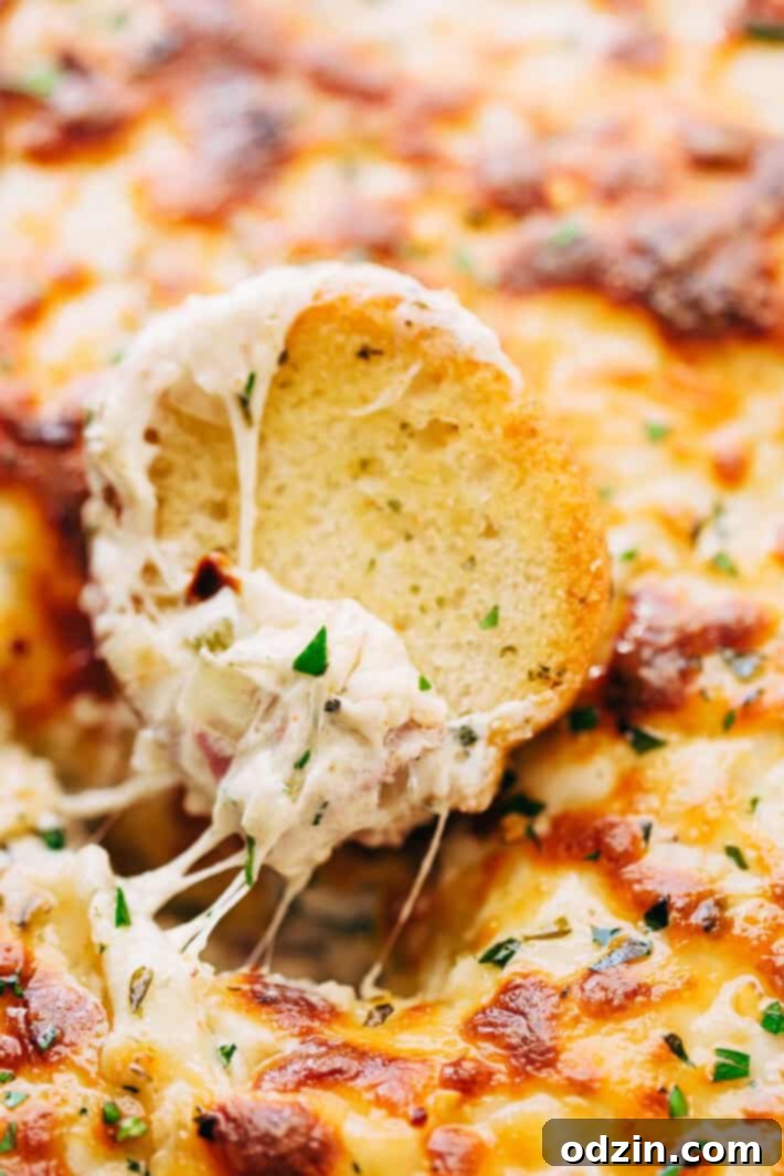 Philly Cheese Steak Dip ready to eat Overhead shot of warm Philly Cheese Steak Dip with various dippers