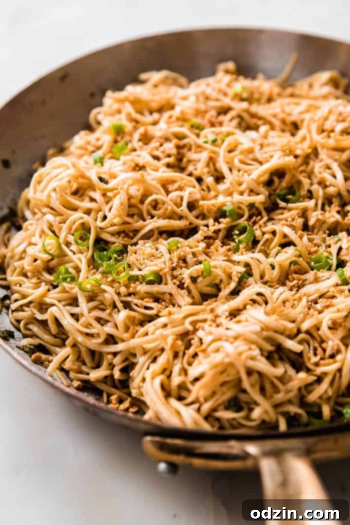 Freshly cooked garlic noodles being stirred in a large pan, ready to serve
