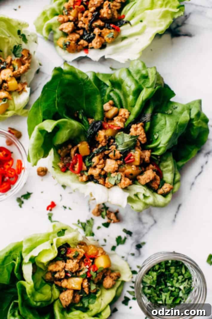 Springtime Basil Chicken Lettuce Wraps - basil chicken stuffed in lettuce wraps with garlic, red chilies, and sweet pineapple to tame that heat! The perfect protein-packed, low carb meal! #lettucewraps #thaibasilchicken #basilchicken #chickenlettucewraps | Littlespicejar.com