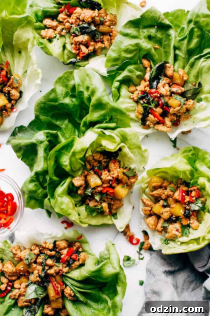 Springtime Basil Chicken Lettuce Wraps - basil chicken stuffed in lettuce wraps with garlic, red chilies, and sweet pineapple to tame that heat! The perfect protein-packed, low carb meal! #lettucewraps #thaibasilchicken #basilchicken #chickenlettucewraps | Littlespicejar.com