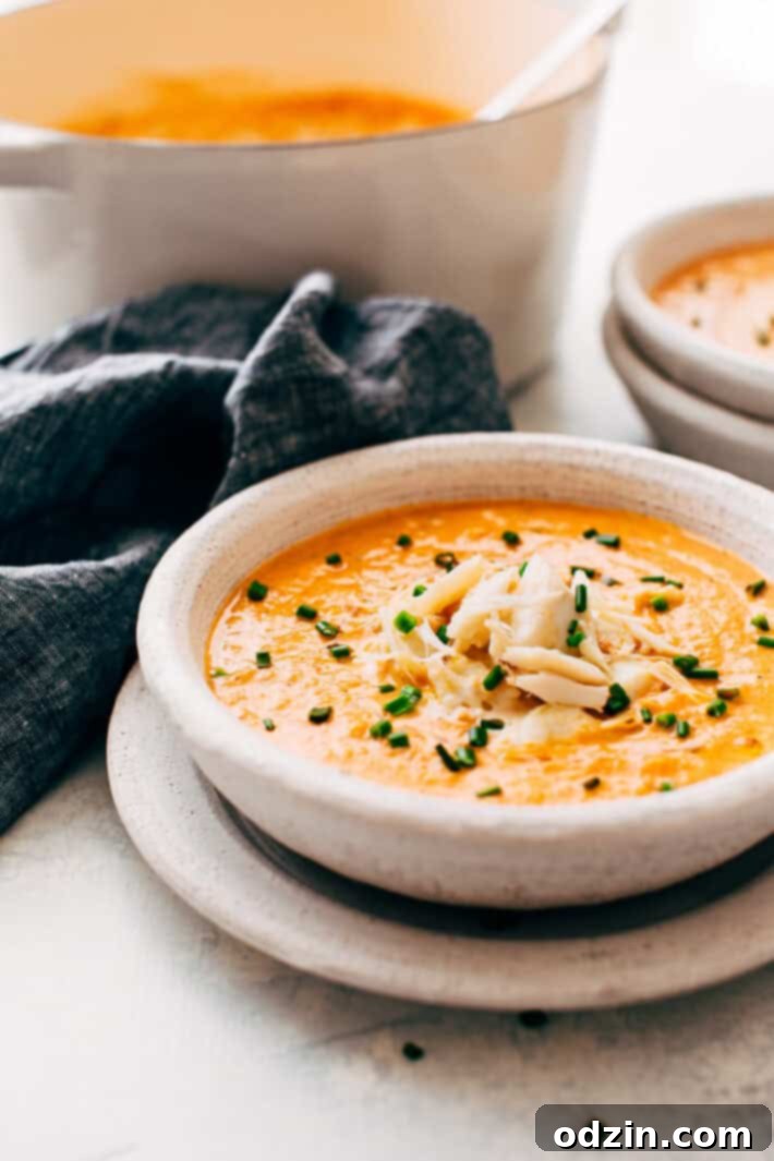 Blushing Tomato Crab Bisque featuring tender jumbo lump crab, smooth cream, and the unique addition of basil pesto for a vibrant flavor profile. #crabbisque #tomatobisque #basilpesto