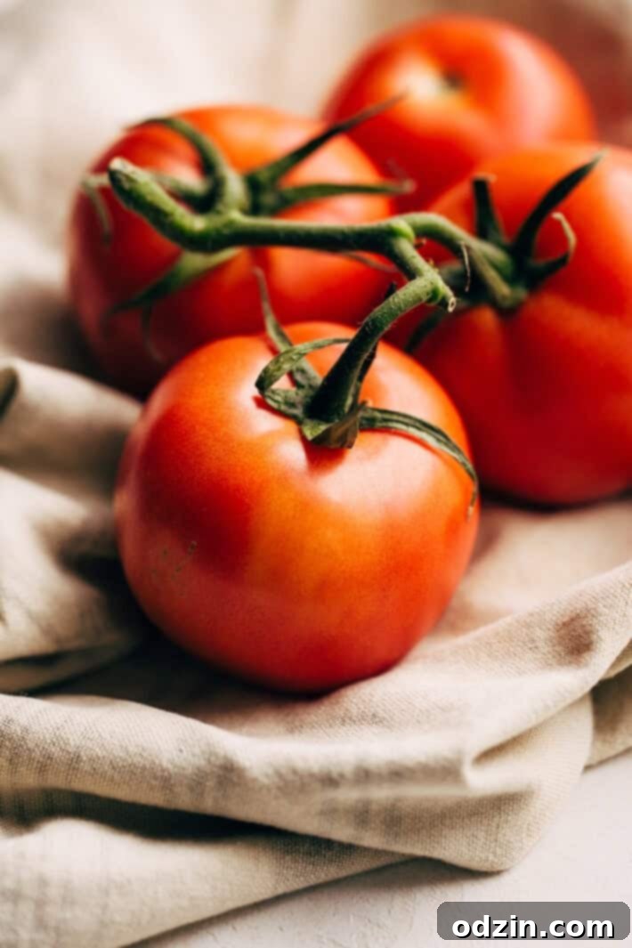 Close-up of vibrant, fresh tomatoes, the star ingredient in this Blushing Tomato Crab Bisque recipe. Their natural sweetness is enhanced by roasting. #freshingredients #tomatorecipe #bisque