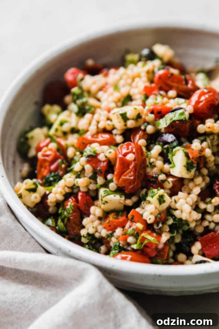 Mediterranean Roasted Garlic Couscous Medley 3 Close-up shot showing texture of pearl couscous, roasted tomatoes, and fresh mozzarella in the salad