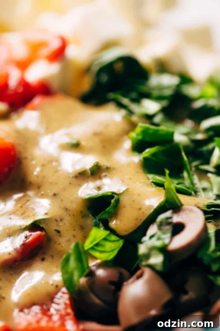 Roasted Garlic Italian Couscous Salad - made with homemade roasted garlic Italian dressing and tons of yummy salad toppings! Perfect for potlucks or picnics! #couscoussalad #italiansalad #salad #picnic #potluck #italiansalad | Littlespicejar.com Italian couscous salad generously drizzled with roasted garlic dressing in a large bowl