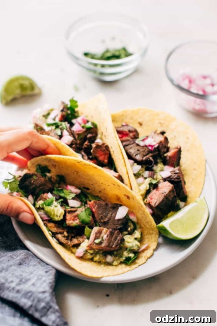 Completed Mojo Steak Tacos on a white plate, garnished and ready to serve
