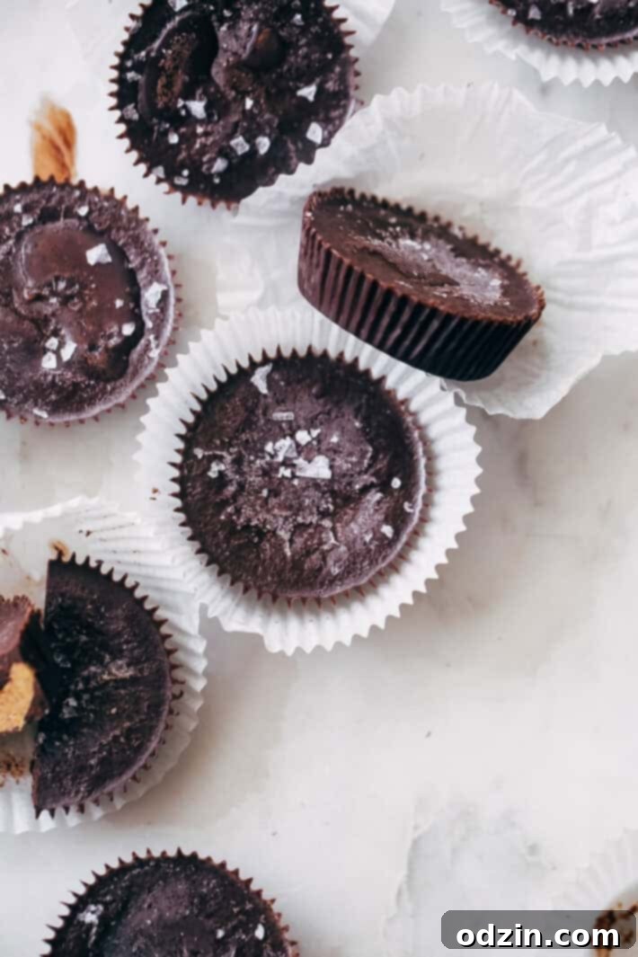 Two hands holding a Mocha Almond Butter Cup, showing its rich texture