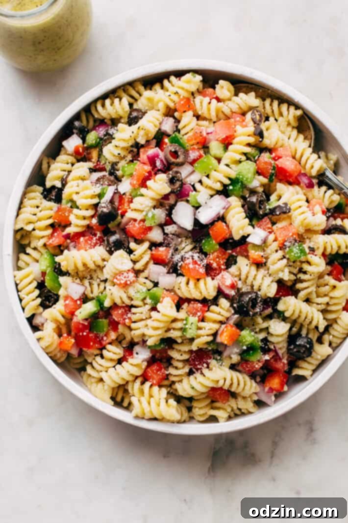 California Pasta Salad - made with homemade roasted garlic Italian dressing and tons of yummy salad toppings! Perfect for potlucks or picnics! #pastasalad #californiasalad #salad #spaghettisalad #potluck #choppedsalad | Littlespicejar.com Delicious California Pasta Salad with homemade roasted garlic Italian dressing, packed with fresh vegetables. Ideal for summer potlucks, picnics, and family gatherings.