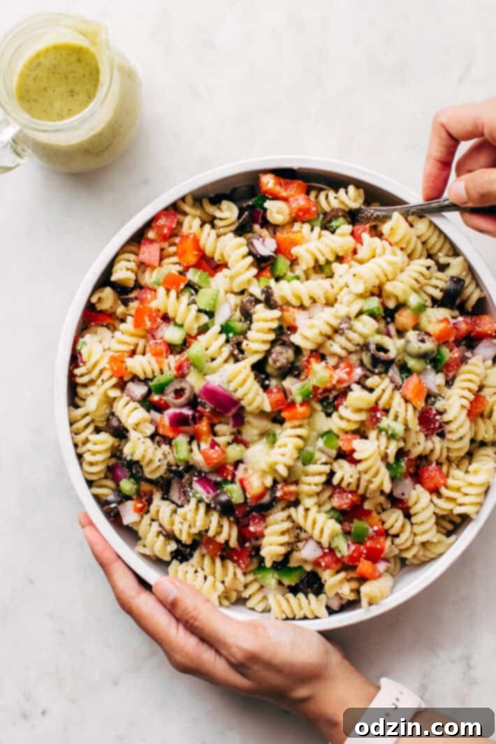 California Pasta Salad - made with homemade roasted garlic Italian dressing and tons of yummy salad toppings! Perfect for potlucks or picnics! #pastasalad #californiasalad #salad #spaghettisalad #potluck #choppedsalad | Littlespicejar.com Overhead view of a large bowl of California Pasta Salad, showcasing its vibrant ingredients and homemade dressing. Ideal for sharing at any event.
