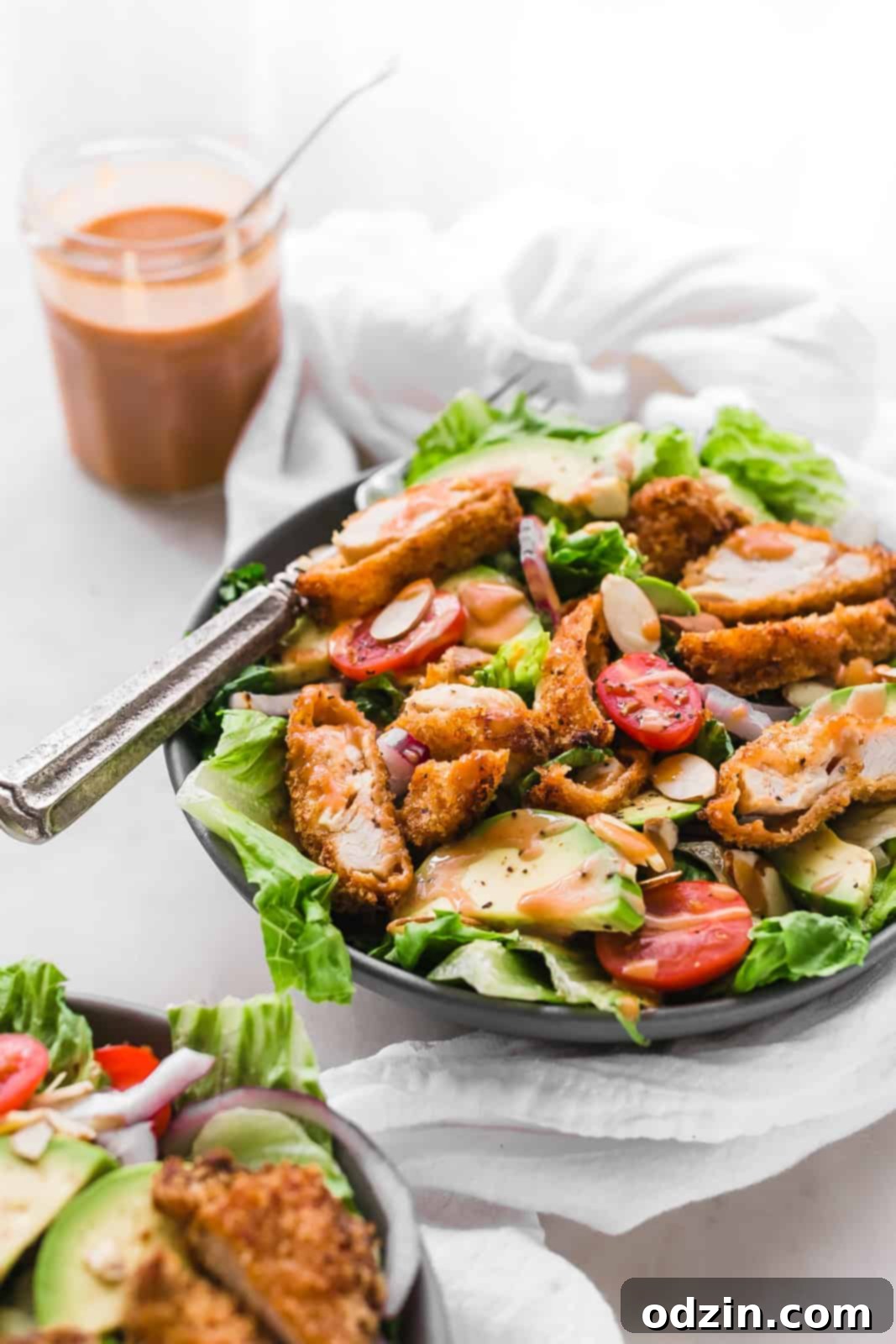 salad bowls topped with sliced almonds crispy chicken strips and dressed in sriracha honey bbq sauce