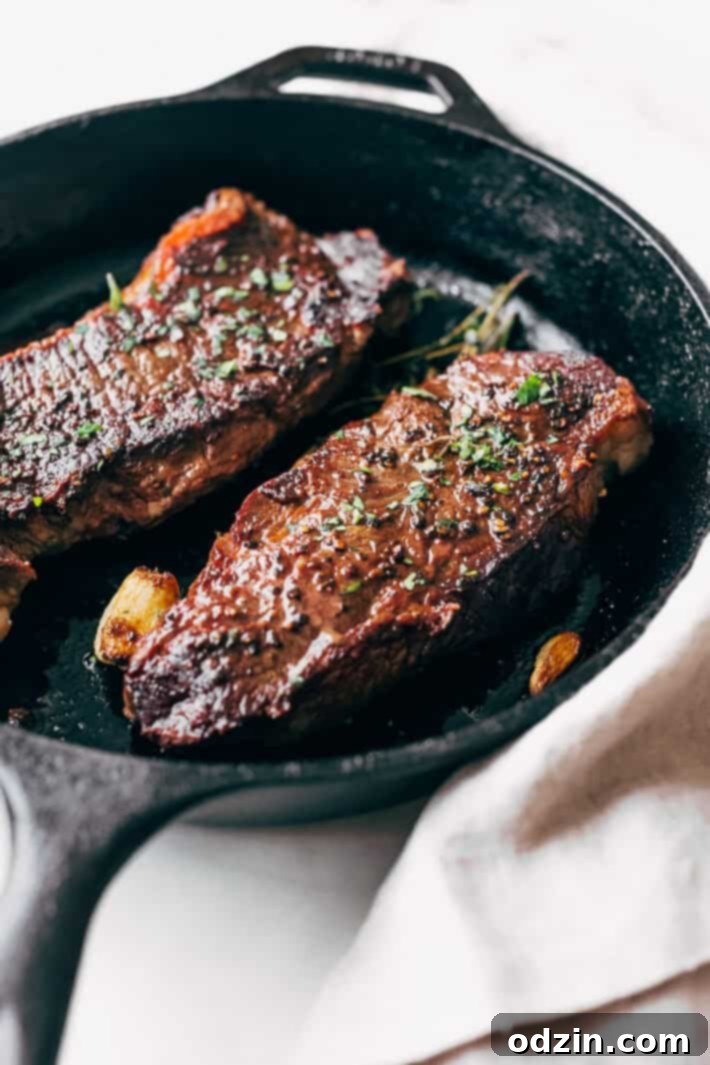 Overhead shot of a complete surf and turf meal with garlic butter steak and shrimp, garnished with fresh rosemary and lemon wedges.