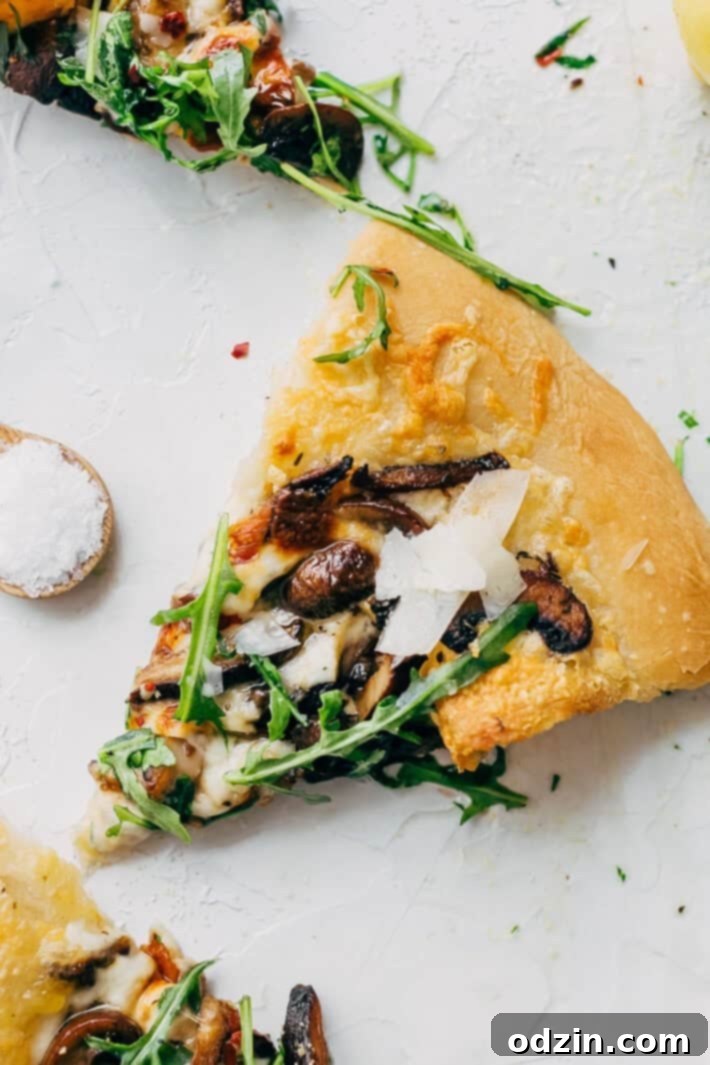 Close-up of a freshly baked Truffled Mushroom Pizza, showcasing the melted fontina and fresh mozzarella cheese along with sautéed garlic butter mushrooms. This easy recipe brings a fancy pizza parlor taste to your kitchen.