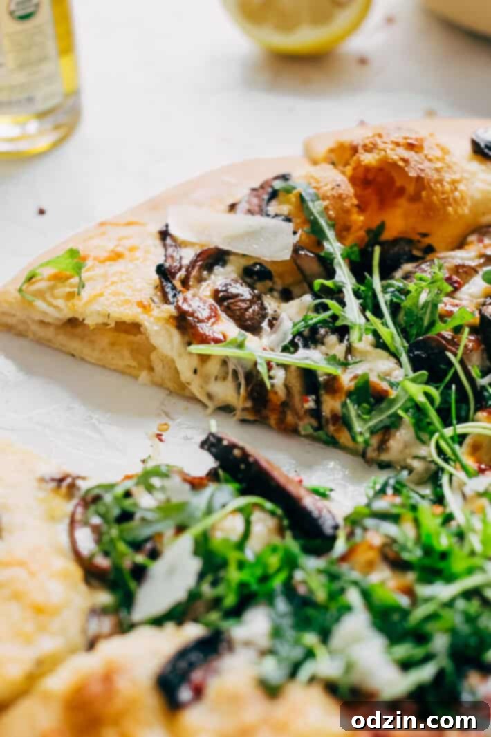 A whole Truffled Mushroom Pizza, perfectly golden-brown, ready to be sliced, garnished with fresh herbs and a drizzle of truffle oil. This gourmet homemade pizza is perfect for mushroom and truffle oil lovers.