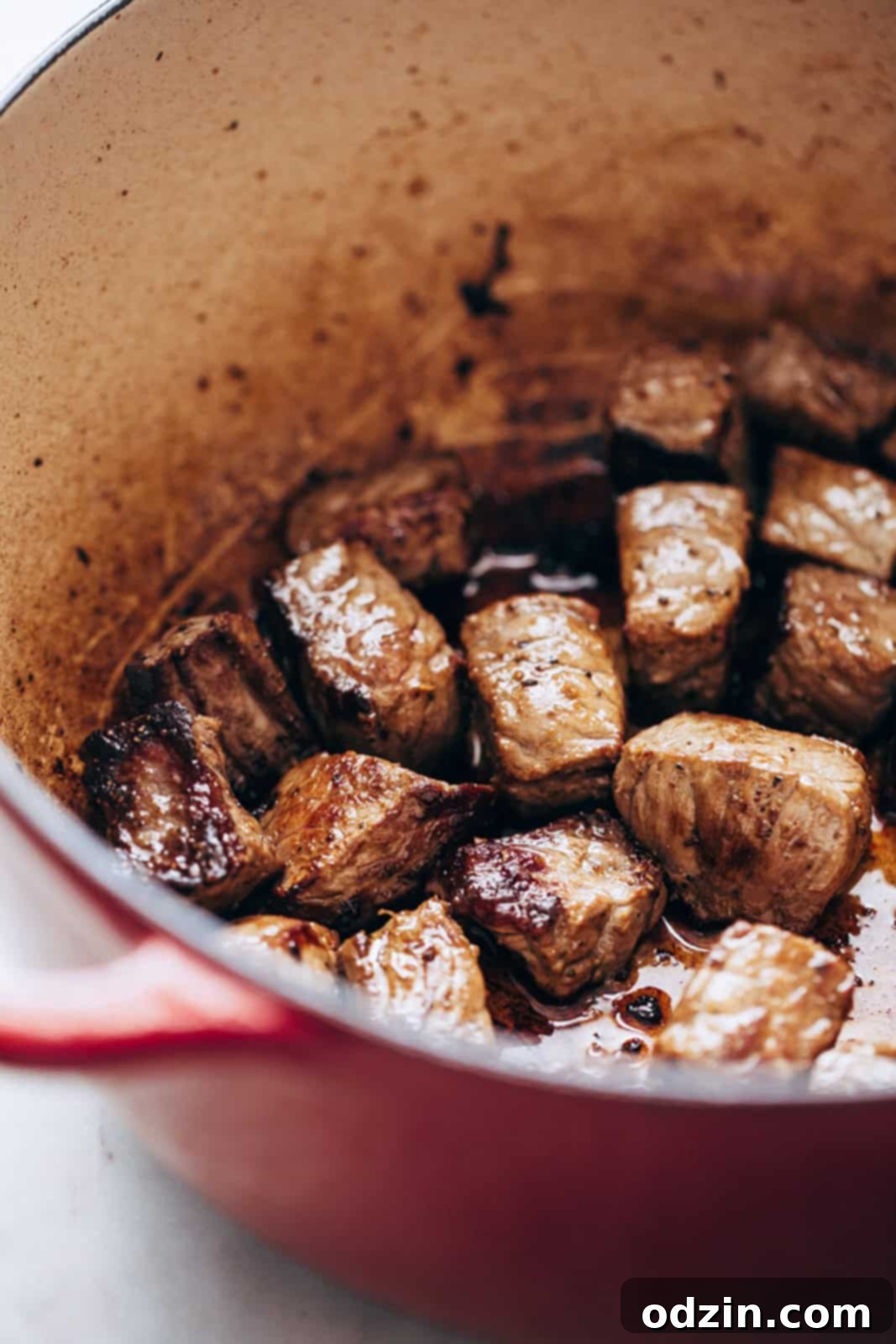 seared stew meat in cast iron pot