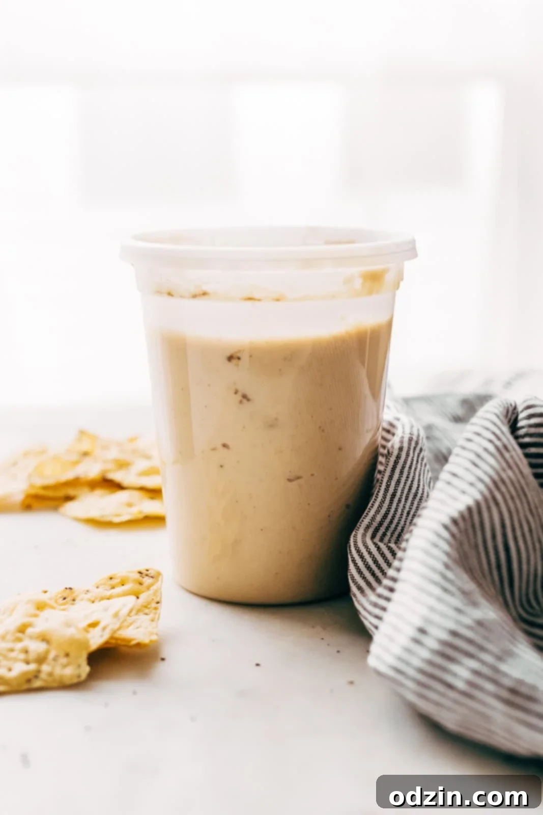 prepared instant pot hummus in quart container with lid on white marble surface