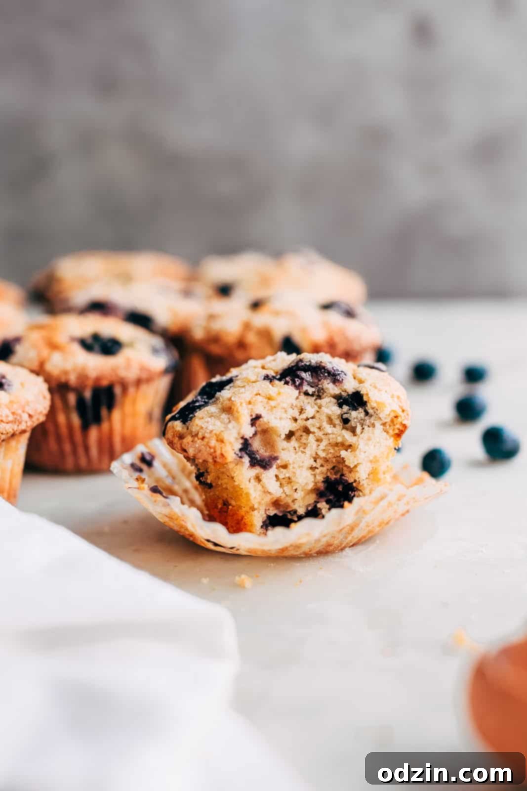 bitten muffin out of liner on white marble