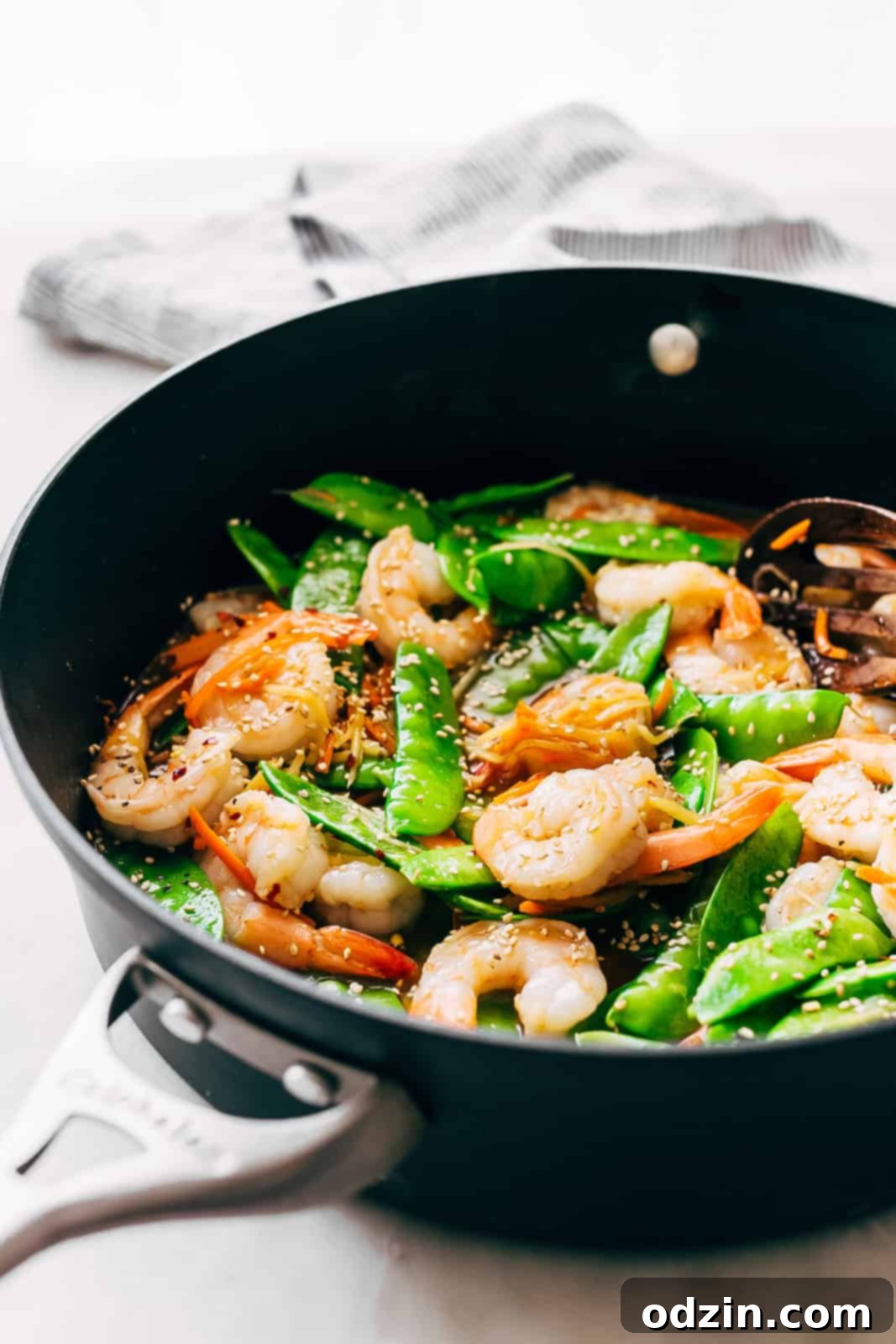 Speedy Ginger Shrimp and Snow Pea Stir Fry 7 side shot of a saute pan holding the freshly prepared shrimp stir fry, showcasing its vibrant colors