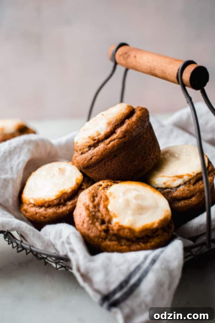 Chai-Spiced Pumpkin Cream Cheese Muffins 9 An inviting display of baked muffins presented in a charming basket, highlighting their golden tops and cheesecake swirls.