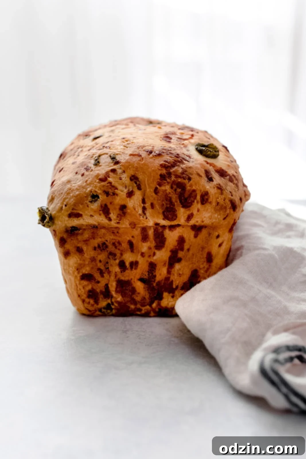 Spicy Cheddar Jalapeño Loaf 11 prepared loaf, unsliced don white surface with tea towel