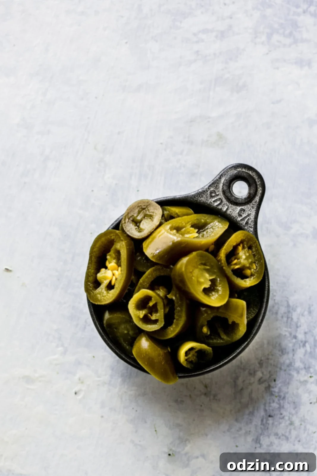 Spicy Cheddar Jalapeño Loaf 5 pickled jalapeños in measuring cup on blue and white surface