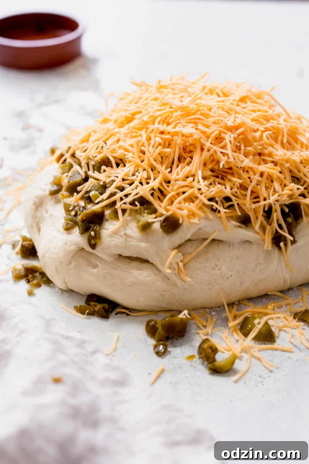 Spicy Cheddar Jalapeño Loaf 7 bread dough with minced pickle jalapeños and shredded cheese on top