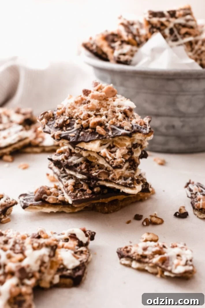 chocolate saltine toffee bark broken and made into a stack on grey surface 