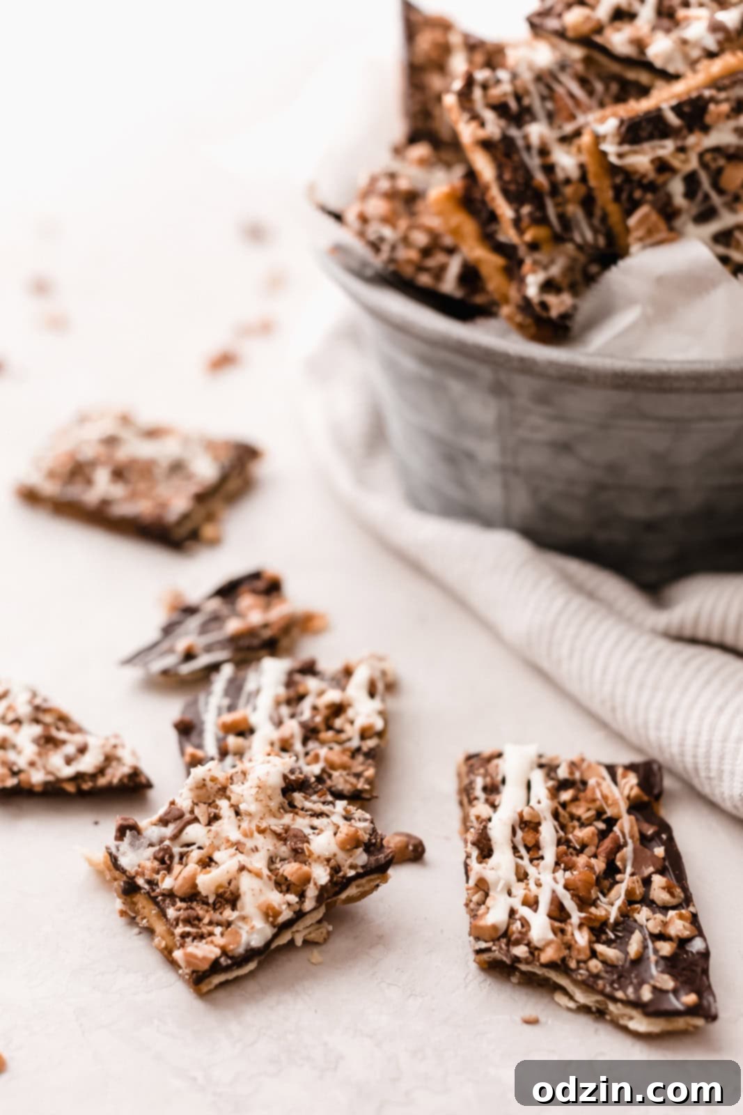 pieces of broken toffee bark on grey surface with galvanized bucketful in the back