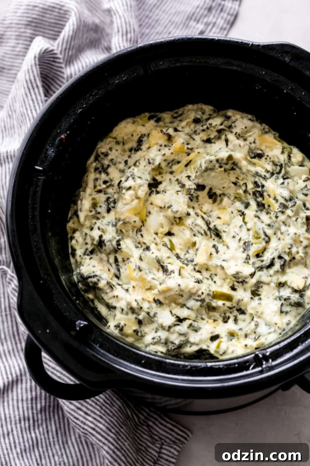 Effortless Slow Cooker Spinach Artichoke Dip 3 Slow cooker filled with prepared spinach artichoke dip, ready to serve