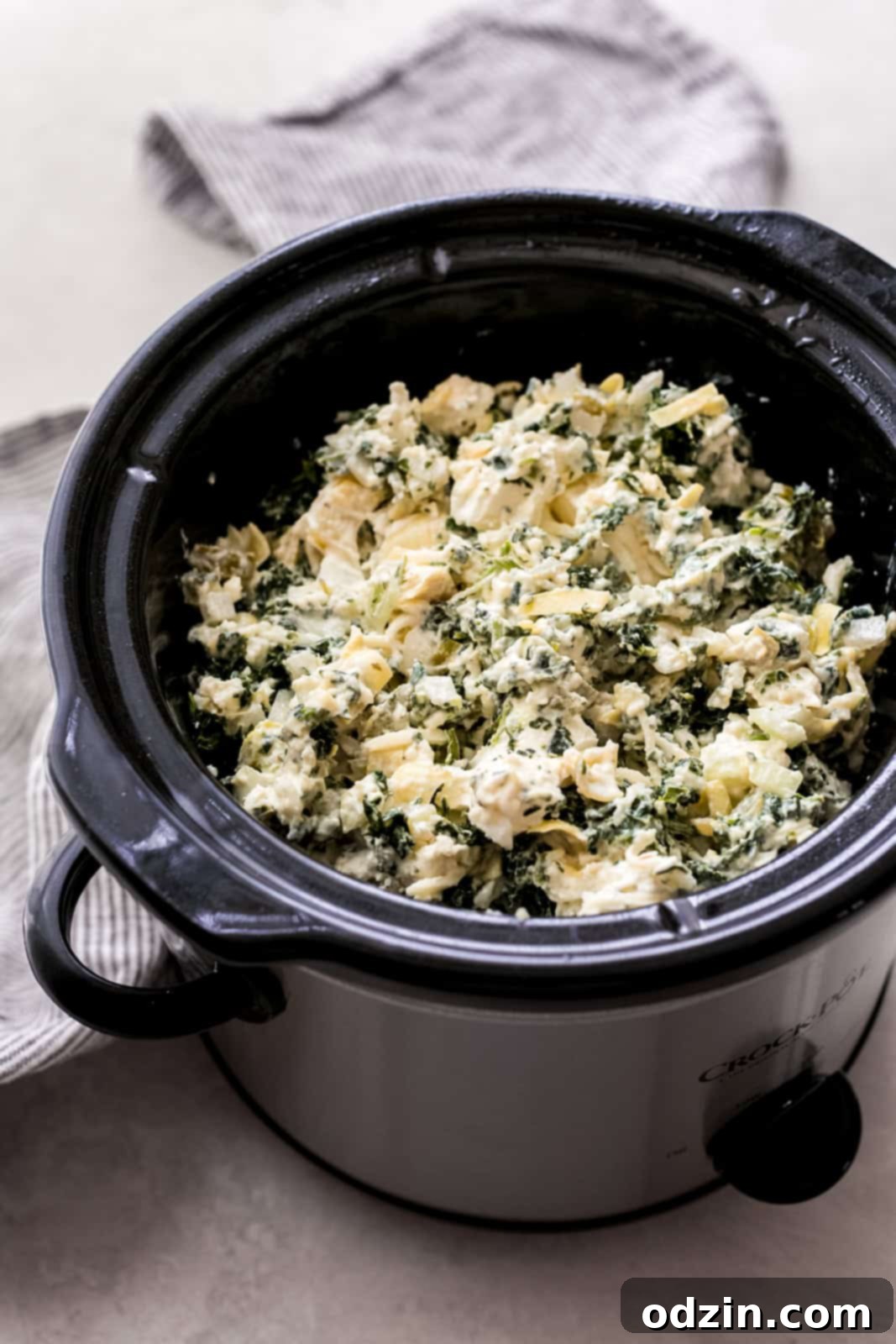 Effortless Slow Cooker Spinach Artichoke Dip 5 Slow cooker loaded with mixed spinach artichoke dip ingredients before cooking