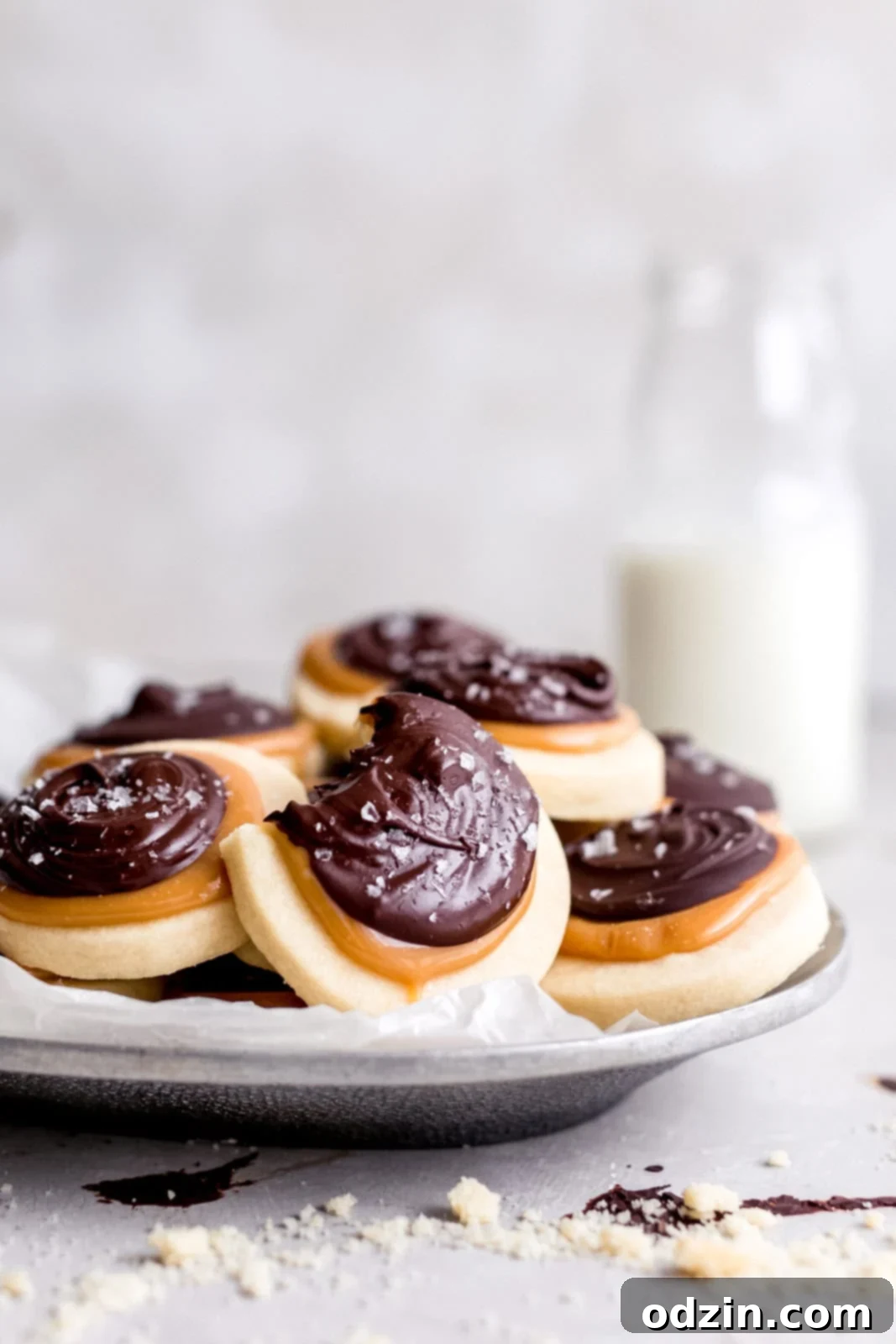 Copycat Twix Shortbread Cookies 4 metal tray holding Twix cookies on gray surface with shortbread crumble